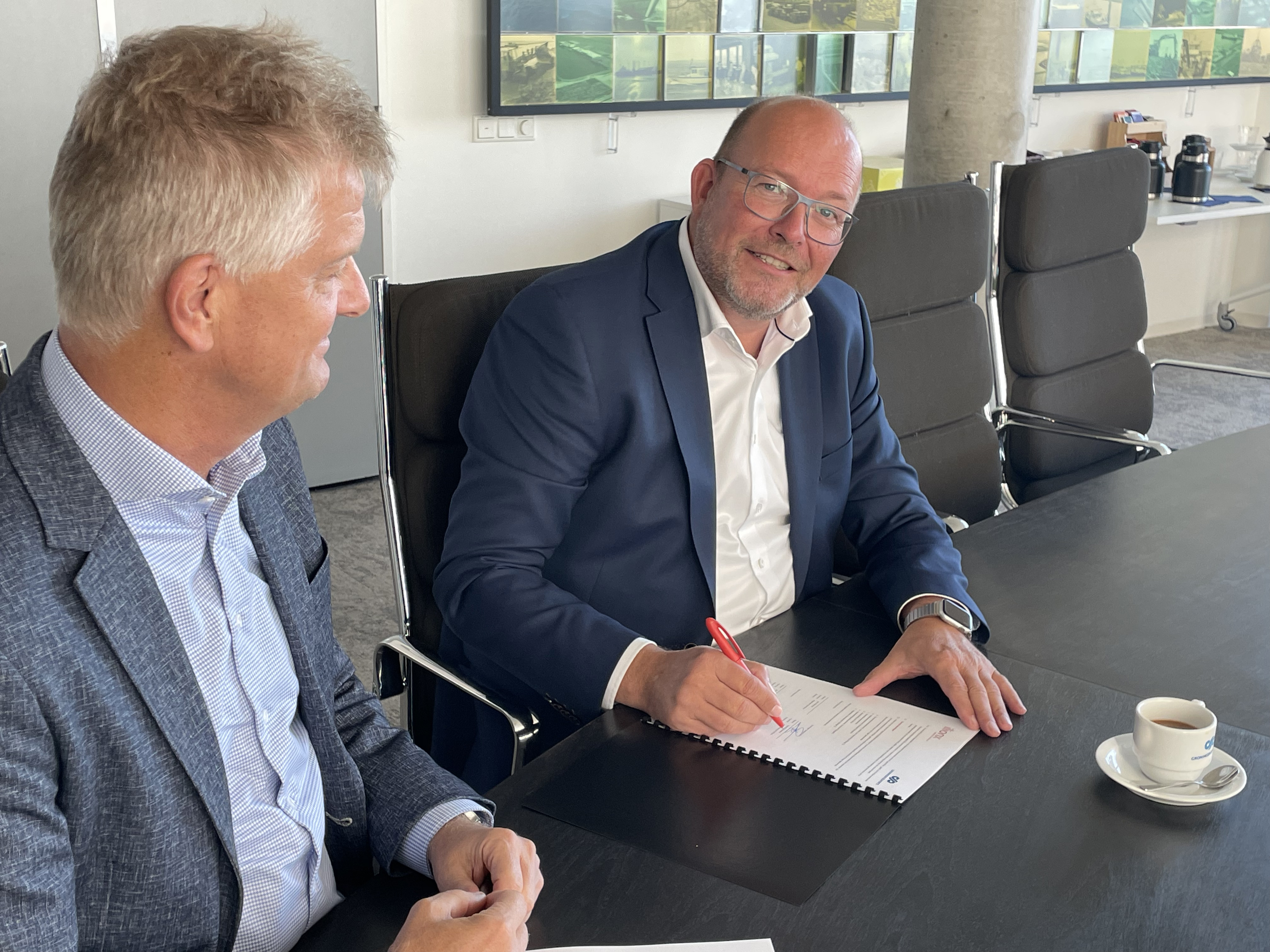 Jan Veltman, CEO van ilionx, en Harold Sanders, CFO van Groningen Seaports, ondertekenen overeenkomst