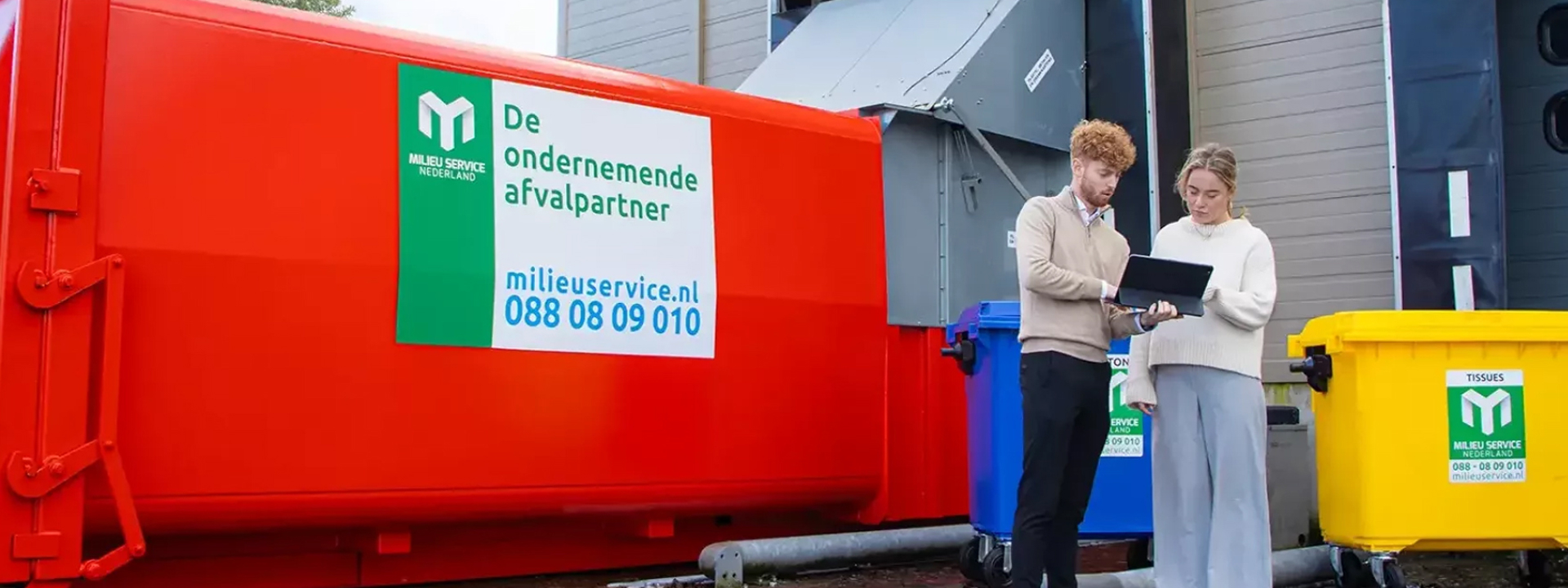 Afbeelding van een rode afvalcontainer met twee medewerkers ervoor, ter ondersteuning aan het klantverhaal Milieu Service Nederland