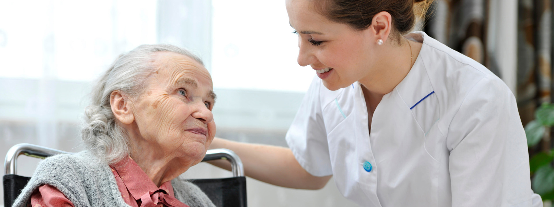 Header Envida | verzorgende helpt een oudere vrouw