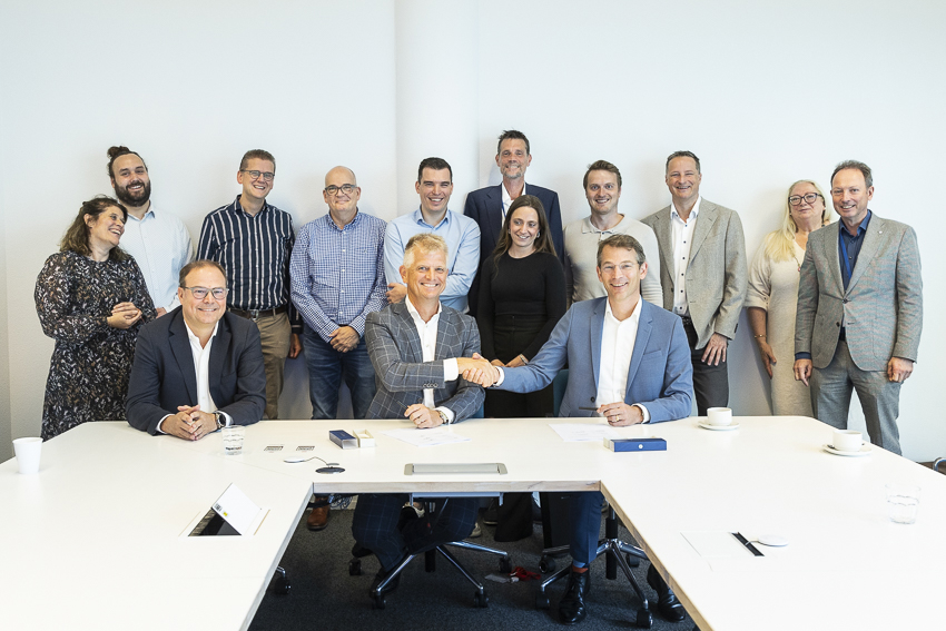 Groep lachende aanwezigen bij gunning cybersecurity aanbesteding TenneT