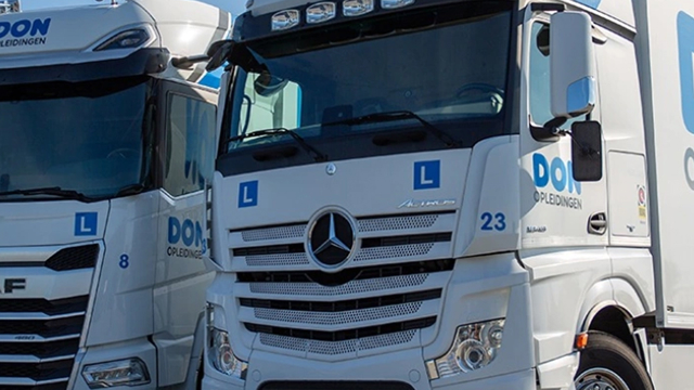 Twee vrachtwagens van DON Opleidingen