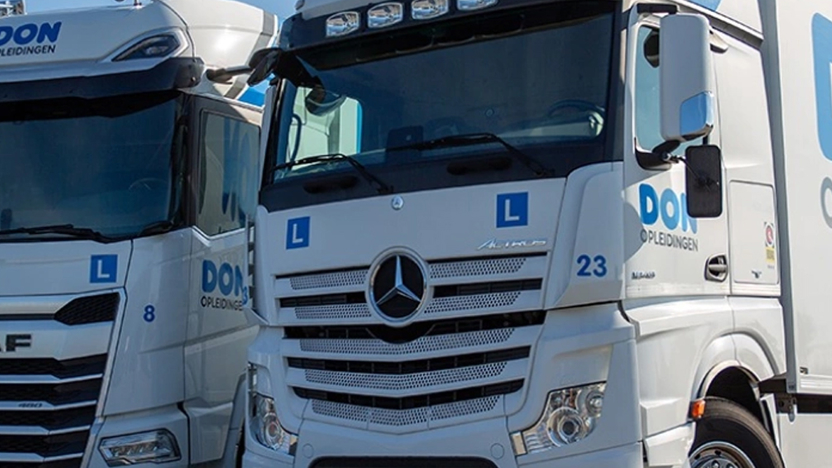 Twee vrachtwagens van DON Opleidingen