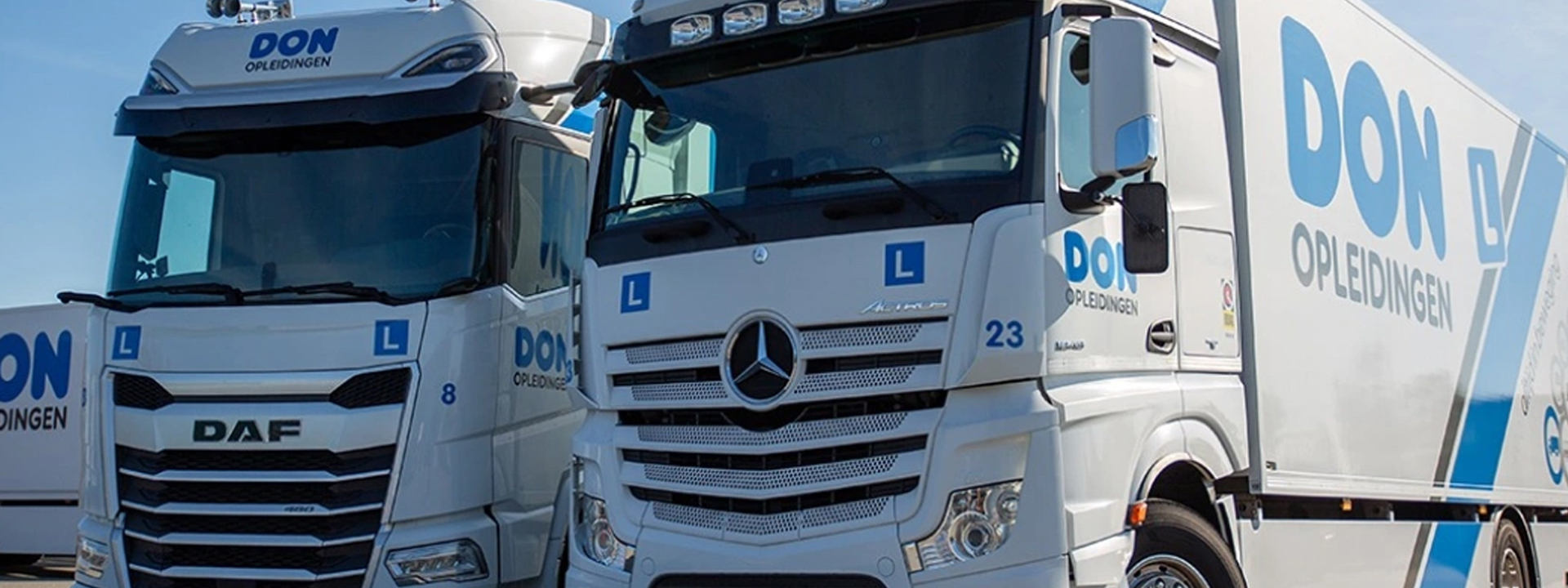 Twee vrachtwagens van DON Opleidingen