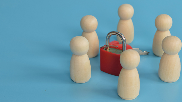 Houten pionnen met sleutel in het midden, ter ondersteuning aan de blog over de Coördinerend Functionaris Gegevensbescherming