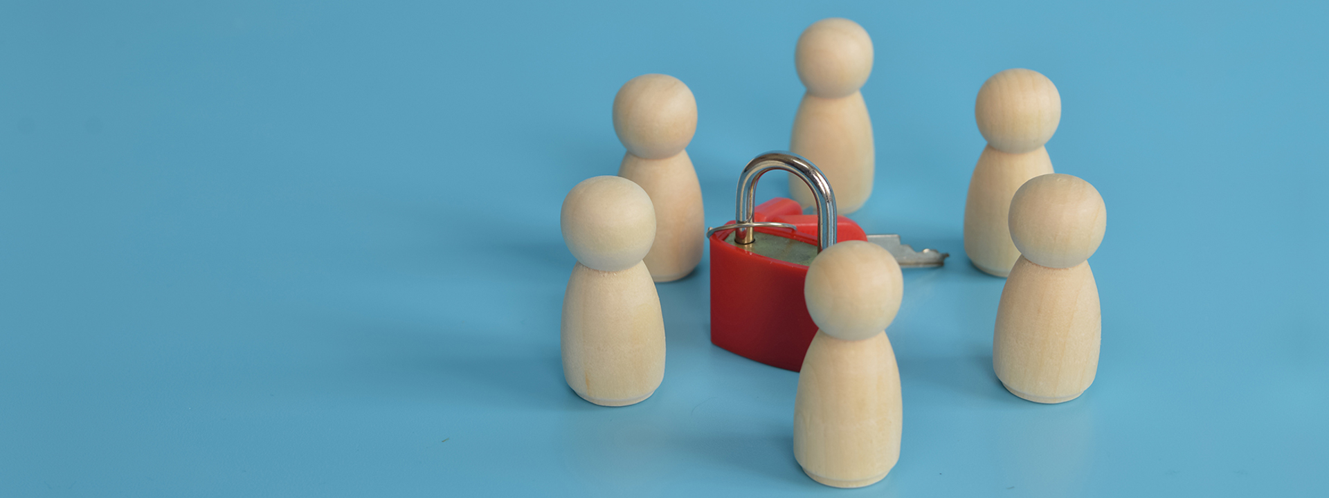 Houten pionnen met sleutel in het midden, ter ondersteuning aan de blog over de Coördinerend Functionaris Gegevensbescherming