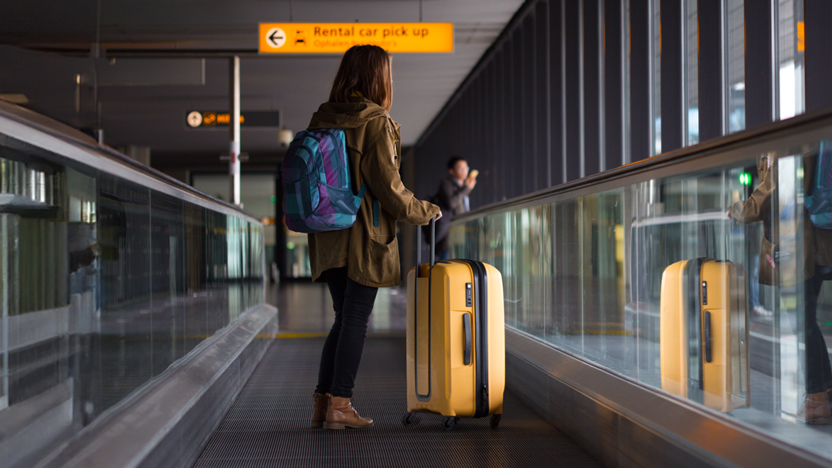 Reiziger met koffer op loopband